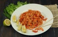 boiled craw fish meat on the plate with lemon slices, Japanese sticks, salad and straw mat closeup photo