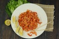 boiled craw fish meat on the plate with lemon slices, Japanese sticks, salad and straw mat closeup photo