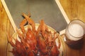 Boiled crawfish, glass of light beer and black chalkboard on a wooden table.