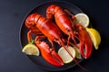 Boiled crayfish with lemon on a black plate.