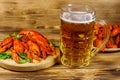 Boiled crayfish and mug of beer on wooden table Royalty Free Stock Photo