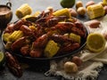 Boiled crayfish with potatoes and corn. With lemon and lime. On a dark blue table. Various recipes and recipe book