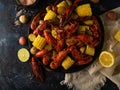 Boiled crayfish with potatoes and corn. With lemon and lime. On a dark blue table. Various recipes and recipe book