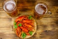 Boiled crayfish and two mugs of beer on wooden table Royalty Free Stock Photo