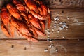 Boiled crayfish on a wooden table among spices, lemon and dill. The concept of food, beer snacks, relaxation in a bar Royalty Free Stock Photo