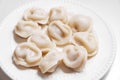 Boiled dumplings are arranged in a circle on a white plate. Royalty Free Stock Photo