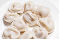 Boiled dumplings are arranged in a circle on a white plate. Royalty Free Stock Photo