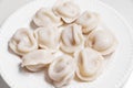 Boiled dumplings are arranged in a circle on a white plate. Royalty Free Stock Photo