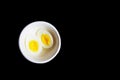 Boiled egg cut in half in a white bowl in black background with space for text Royalty Free Stock Photo