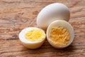 Boiled egg cutout and raw egg with shell on wooden background Royalty Free Stock Photo