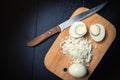 Boiled egg on a cutting board witn knife