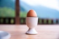 Boiled egg in eggcup on wooden table outside, breakfast eggin white egg cup Royalty Free Stock Photo