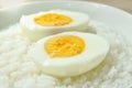 boiled egg half cut topping rice porridge in white bowl on table Royalty Free Stock Photo