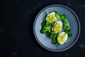 Boiled egg salad, greens mix on a gray plate, top view. Royalty Free Stock Photo