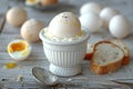 A boiled egg in a white cup with bread and a spoon on a wooden table, a closeup of half boiled eggs on the side. magritte sof Royalty Free Stock Photo