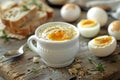 A boiled egg in a white cup with bread and a spoon on a wooden table, a closeup of half boiled eggs on the side. magritte sof Royalty Free Stock Photo