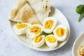 Boiled eggs cutted in halfs seasoned with pepper and salt with pita bread on a plate, appetizers meal