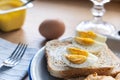 Boiled eggs on toast bread with butter and yogurt. Healthy breakfast on a wooden table, close up Royalty Free Stock Photo