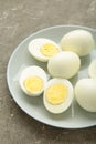 Boiled eggs in white ceramic plate on grey background. Vertical photo Royalty Free Stock Photo