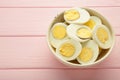 Boiled eggs in white ceramic plate on pink background. Space for text Royalty Free Stock Photo