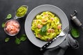 Boiled fettuccine pasta with fresh spinach pesto and shrimps on black background. Italian cuisine. Healthy dish for lunch Royalty Free Stock Photo