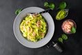 Boiled fettuccine pasta with fresh spinach pesto and shrimps on black background. Italian cuisine. Healthy dish for lunch Royalty Free Stock Photo