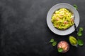 Boiled fettuccine pasta with fresh spinach pesto and shrimps on black background. Italian cuisine. Healthy dish for lunch Royalty Free Stock Photo