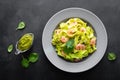 Boiled fettuccine pasta with fresh spinach pesto and shrimps on black background. Italian cuisine. Healthy dish for lunch Royalty Free Stock Photo