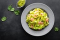 Boiled fettuccine pasta with fresh spinach pesto and shrimps on black background. Italian cuisine. Healthy dish for lunch Royalty Free Stock Photo