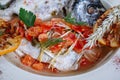 Boiled fish with sauce and fried tomatoes Royalty Free Stock Photo