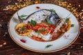 Boiled fish with sauce and fried tomatoes Royalty Free Stock Photo