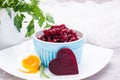 Boiled grated beet in a bowl, chiken egg and parsley