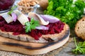 Boiled grated beets, pieces of herring, red onions, nuts on whole grain bread. Royalty Free Stock Photo