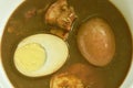 Boiled half cut egg with fat pork in herb brown soup on bowl