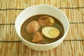 Boiled half cut egg with fat pork in herb brown soup on bowl