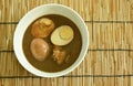 Boiled half cut egg with fat pork in herb brown soup on bowl