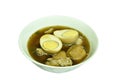 Boiled half cut egg with tofu in herb brown soup on bowl