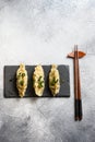 Boiled Japanese gyoza, dumplings snack  on black stone board slate over grey stone textured table background top view Royalty Free Stock Photo