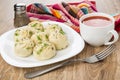 Boiled khinkali with dill in plate, tomato juice, pepper