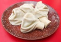 Boiled khinkali on a red table