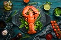 Boiled lobster with vegetables on a black stone plate. Seafood. Top view.