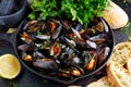 Boiled mussels in iron pan cooking dish. with herbs, butter, lime, parsley, garlic and fresh bread. Royalty Free Stock Photo