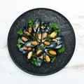 Boiled mussels with parsley and spices on a black plate. Top view. Royalty Free Stock Photo