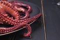 Boiled octopus on black plate Royalty Free Stock Photo