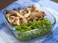 Boiled oyster mushroom and cowslip creeper in clear bowl and was placed on the blue tablecloth