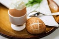 Boiled and peeled egg in cup, cracked egg, spoon, dill and towel on plate Royalty Free Stock Photo