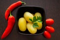 Boiled potatoes with chili peppers and tomatoes on a dark background Royalty Free Stock Photo