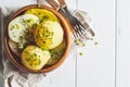 Boiled potatoes with greens in a wooden bowl, white background, top view Royalty Free Stock Photo