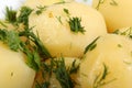 Boiled potatoes with oil and chopped dill leaves and parsley leaves in white porcelain plate Royalty Free Stock Photo