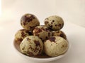 Boiled Quail eggs in the plate on the white background.